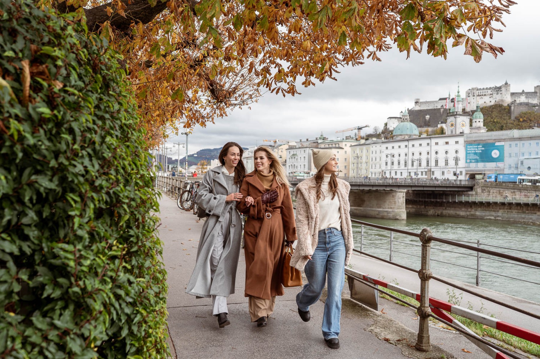 Friends exploring the city of Salzburg along the Salzach River promenade © Lorenz Masser